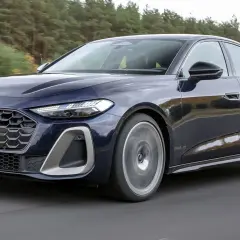 Ciemnoniebieskie Audi A5 w ruchu drogowym, podczas testu. Elegancka linia nadwozia i sportowy charakter.