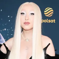 Luna w stylizacji na Eurowizję, z długimi blond włosami i perłowym naszyjnikiem.