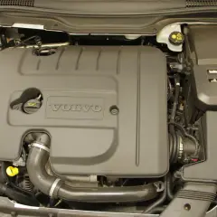 Silnik Volvo V50 1.6 diesel. Widoczna czarna osłona silnika z logo Volvo, przewody i elementy układu dolotowego.