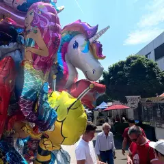 Bunte Ballons mit Einhorn und Meerjungfrau beim Stadtfest Bensberg. Menschen schlendern an Ständen vorbei.