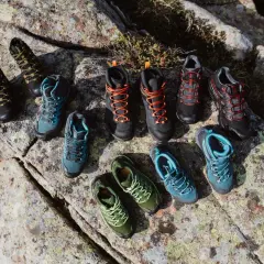 A collection of hiking boots and shoes in various colors, arranged on rocks. Even well-made shoes can degrade over time if not worn, a process that can seem mysterious.