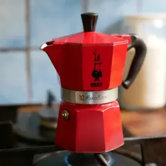 Czerwona kawiarka Bialetti Moka Express na kuchence, gotowa do zaparzenia aromatycznej kawy. To klasyczny sposób na espresso w domu.