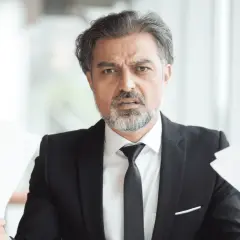 Hombre con traje y papeles, preocupado por cuanto cobra una inmobiliaria por alquilar un piso.