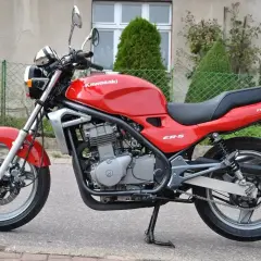 Czerwony Kawasaki ER-5, gotowy do jazdy po miejskich ulicach.