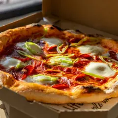 Pyszna pizza z pepperoni, mozzarellą i papryką, prosto z pieca. Zastanawiasz się, skąd pochodzi pizza? Z Włoch, oczywiście!