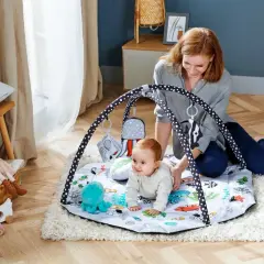 Mama bawi się z dzieckiem na macie edukacyjnej z motywem podwodnym. Idealna mata dla niemowlaka do rozwoju.