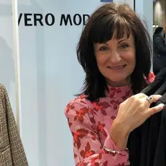 Kvinna i blommig blus vid klädställning med plagg från Vero Moda rea.