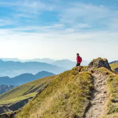 Wanderer auf einem Bergkamm in Deutschland, mit Blick auf eine weite Alpenlandschaft.