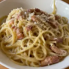 En krämig portion pasta carbonara med knapriga bitar av fläsk och rikligt med svartpeppar.