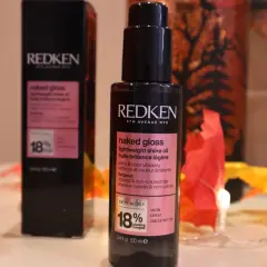 Dwa opakowania olejków do włosów Redken Naked Gloss, które nadają blask i witalność.