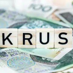 Litery K, R, U, S na tle polskich banknotów. Symbolizują dodatki do renty z tytułu całkowitej niezdolności do pracy.