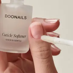 Applicazione di un prodotto per ammorbidire le cuticole, un modo naturale per prendersi cura delle unghie.