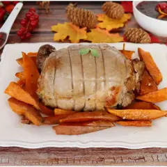 Un succulento arrosto di tacchino, cotto alla perfezione, servito su un letto di patate dolci arrostite. Un piatto autunnale invitante.