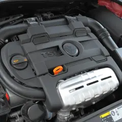 Silnik 1.4 TSI z widocznym logo VW. Widoczne elementy układu dolotowego i osłony silnika.