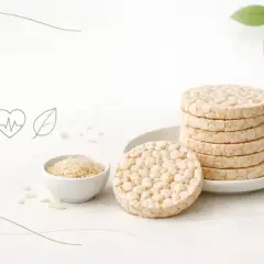Stos ryżowych wafli i miseczka z ryżem. Czy wafle ryżowe są zdrowe? Ikony zdrowia i diety sugerują odpowiedź.