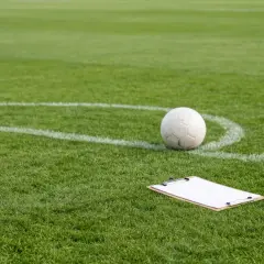Piłka nożna i tablica na rogu boiska. Nawet z handicapem, każdy mecz to szansa na zwycięstwo.
