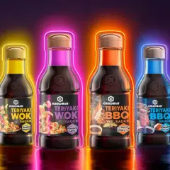 Fyra flaskor Kikkoman teriyaki marinad i olika smaker, omgivna av neonljus.