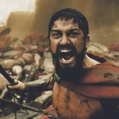 Leonidas, med svärdet höjt, vrålar i strid bland fallna krigare. En ikonisk scen från rollistan i 300.