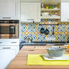 Azulejos vibrantes con motivos florales y geométricos ofrecen fantásticas ideas para pared de cocina. Blanco y azul sobre amarillo crean un ambiente alegre.