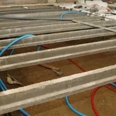 Construction d'un vide sanitaire avec poutrelles béton et tuyaux bleus. Préparation pour comment ventiler un vide sanitaire.