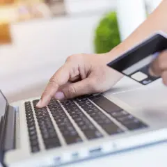 Osoba wpisuje dane karty płatniczej na laptopie, realizując przelewy przychodzące BNP Paribas.