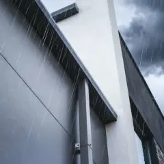 Deszcz spływa po łączeniu płyt warstwowych nowoczesnego budynku.
