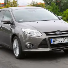 Szary Ford Focus MK3 1.6 TDCI w wersji kombi jedzie po drodze.