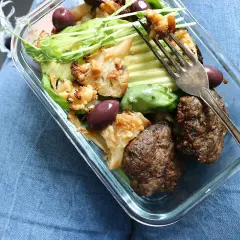 En snabb matlåda med köttbullar, blomkål, avokado och oliver. Perfekt för en hälsosam lunch på språng.