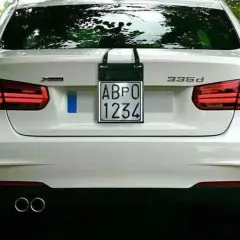 Parte posteriore di un'auto bianca con targa prova "ABPO 1234" appesa.