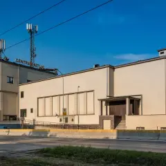 Betonowy budynek z napisem "CENTRUM SZTUKI" na dachu, z wieżami telekomunikacyjnymi. Obok widoczna droga i zieleń.