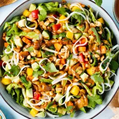 Bunter Sommerrollen Salat mit Reisnudeln, Mango, Avocado, Erdnüssen und cremiger Erdnusssauce.