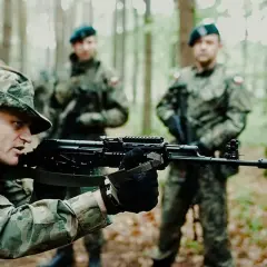 Żołnierze na szkoleniu podstawowym wojsko ćwiczą celowanie z karabinów w lesie.