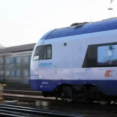 Pociąg PKP Intercity Stadler ED160-007 mija budynek. Może to być początek podróży lub zwrot biletu PKP.