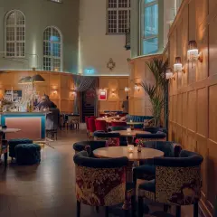 Elegant jazz bar i Stockholm med sammetssoffor, mönstrade stolar och en stilfull bar.