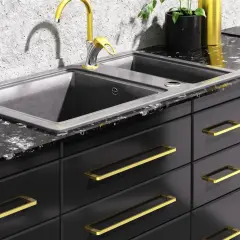 Elegancka kuchnia z czarnymi frontami i złotymi uchwytami. To świetny pomysł na uchwyty do mebli, dodają blasku i stylu.