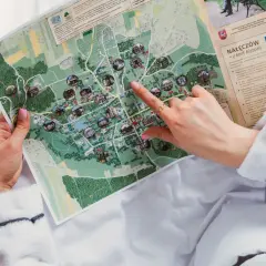 Ręka wskazuje na mapę Nałęczowa, planując, kiedy są wakacje i co zwiedzić.