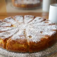 Gâteau mascarpone saupoudré de sucre glace, prêt à être dégusté avec une tasse de café.