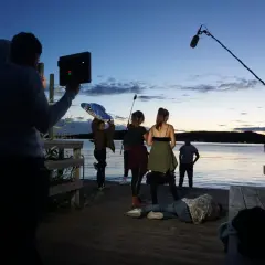 Suheib Saleh filmar en scen vid vattnet i skymningen. En person ligger på bryggan, medan andra filmar och håller mikrofon.