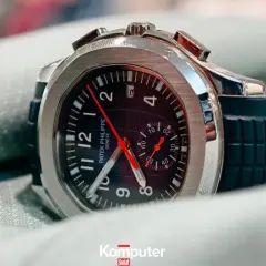 Elegancki zegarek Patek Philippe, model inspirowany stylem Marie Philippe, z czarną tarczą i gumowym paskiem, leży na zielonym materiale.