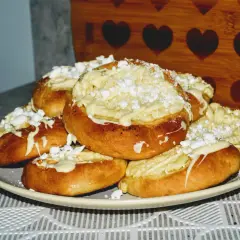 Pyszne drożdżówki bez mleka z kremowym nadzieniem i posypką z cukru pudru. Idealne na deser lub słodką przekąskę.