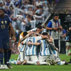 Piłkarze Argentyny świętują zwycięstwo, przytulając się na boisku.