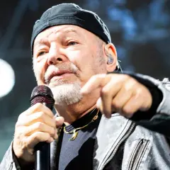 Vasco Rossi canta con passione, puntando il dito. I suoi testi, come "non mi va", risuonano potenti.