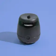 Czarny odstraszacz Thermacell na niebieskim tle. Zapewnia strefę wolną od kleszczy, chroniąc ludzi.