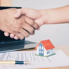 Poignée de main sur un contrat immobilier, symbolisant un accord respectant la loi du 6 juillet 1989 sur les réparations locatives.