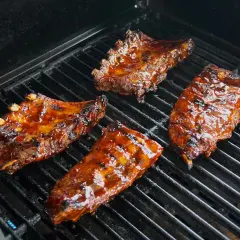 Soczyste żeberka w sosie barbecue grillują się na ruszcie. Idealne do marynowania w domowych sosach.