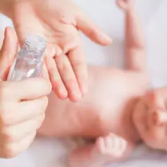 Delikatna oliwka dla noworodka w dłoniach mamy, gotowa do pielęgnacji maluszka.