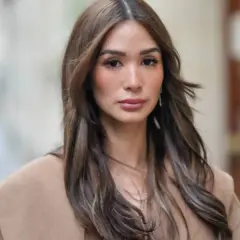 Mujer con cabello castaño largo y ondulado, viste un abrigo color camel. Su maquillaje old money resalta su belleza natural con tonos suaves y elegantes.