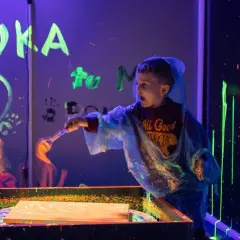 Chłopiec maluje farbami fluorescencyjnymi w ciemni. Niezapomniane urodziny dziecka w Szczecinie.