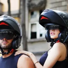 Pareja lista para rodar con sus cascos modulares, ofreciendo protección y estilo.