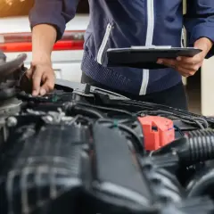 Mechanik sprawdza układ wtrysku paliwa, notując obserwacje na tablecie.